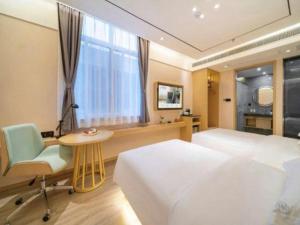 a bedroom with a bed and a desk and a window at Deep Sleep Hotel Nanjing Confucius Temple Metro Station in Nanjing