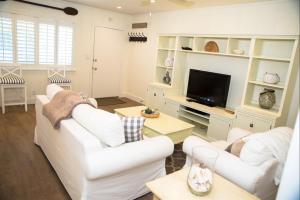 a living room with white furniture and a flat screen tv at 4980 Sandyland Road #216 in Carpinteria
