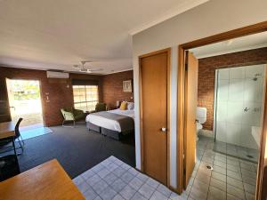 a hotel room with a bed and a bathroom at Bridge Motor Inn Tocumwal in Tocumwal