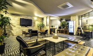 金海市Gimhae Browndot Hotel Waterpark的带沙发、椅子和电视的客厅