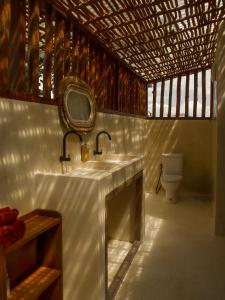 La salle de bains est pourvue d'un lavabo, d'un miroir et de toilettes. dans l'établissement Anna Villas by Sumba-Beach, à Memboro 37 autres photos