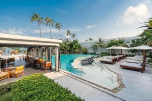 an outdoor pool at a resort with tables and chairs at The Culture Samui in Bangrak Beach
