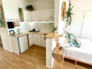 a small kitchen with white cabinets and a bed in a room at Island Views in Airlie Beach