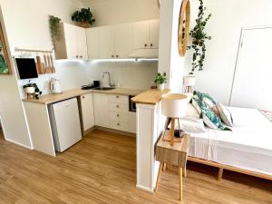 a small room with a bed and a kitchen at Island Views in Airlie Beach