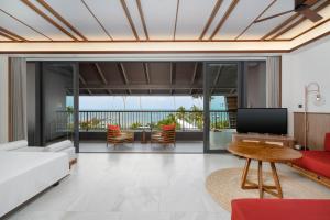 a living room with a white couch and a television at The Culture Samui in Bangrak Beach