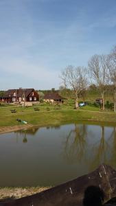 Lauku Mājas Ēmužas في Dārte: a body of water with houses in the background