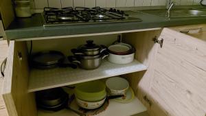 a kitchen drawer with pots and pans and a stove at Etna Maison in Zafferana Etnea