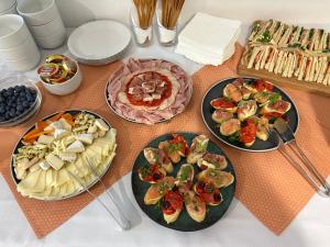 a table with three plates of food and sandwiches at Garni G Hotel Žilina in Žilina