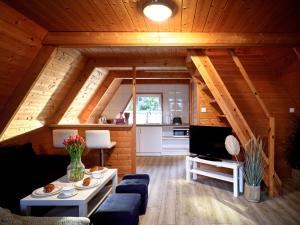 a living room of a log cabin with a couch and a table at Mholiday Sarbinowo u Kaspra in Sarbinowo