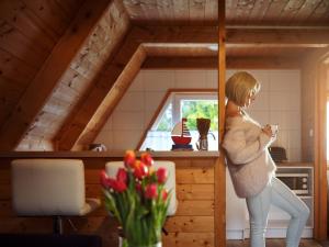 a woman standing in a room in a tiny house at Mholiday Sarbinowo u Kaspra in Sarbinowo