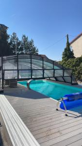 a swimming pool with a bridge over a wooden deck at Mholiday Sarbinowo u Kaspra in Sarbinowo