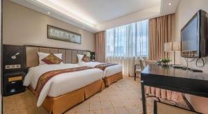 a hotel room with a large bed and a television at Nanning Yongjiang Hotel in Nanning