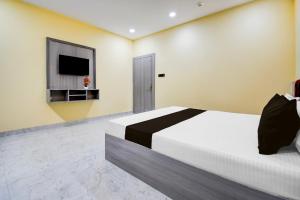 a bedroom with a bed and a flat screen tv at Super Townhouse Taramandal Near Sahara States in Bhauvāpār +22 photos