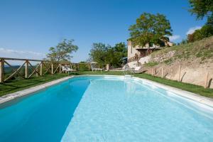 duży basen z niebieską wodą w obiekcie Casa Vacanze Toscana Il Puggio w mieście Capolona