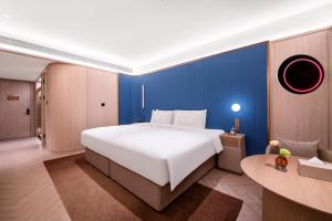 Uma cama ou camas num quarto em 西安高新锦业路桔子水晶酒店