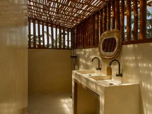 une salle de bain avec deux lavabos et une fenêtre dans l'établissement Anna Villas by Sumba-Beach, à Memboro