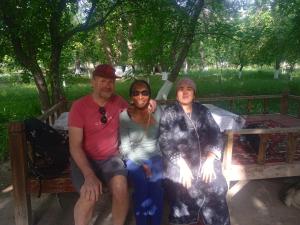 a group of three people sitting on a bench at Porasht homestay in Farish