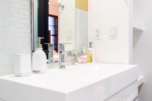 une salle de bain blanche avec un lavabo et un miroir dans l'établissement Stylish loft 2 queens & 2 sofas, à Los Angeles