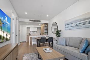una sala de estar con un sofá y una mesa en Charming 1-Bed with Rooftop Access & Parking, en North Fremantle