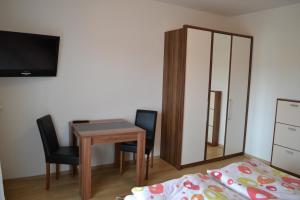 1 dormitorio con escritorio, 1 cama y espejo en Appartements Bürger, en Krumpendorf am Wörthersee