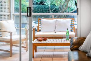 シドニーにあるRushcutters Bay Retreat with Balcony - New Listingのソファとテーブルのあるリビングルーム