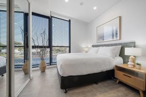 Un dormitorio con una cama grande y grandes ventanales. en Stylish Studio Near Fremantle Cafés and Beaches, en North Fremantle