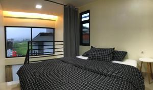 a bedroom with a bed and a large window at Compound holiday home - 1 bedroom - Backyard Loft in Wonosobo