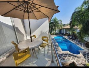 a patio with a table and chairs and an umbrella at Casa Tamarindo in Alpuyeca