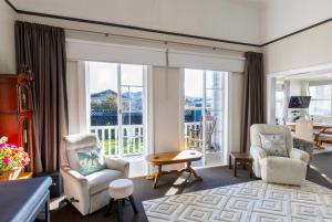 里夫顿Haere Mai Reefton Heritage Holiday Home的客厅配有椅子和大窗户