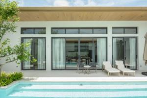 ein Haus mit Swimmingpool und Terrasse in der Unterkunft Mouana Breeze Mai Khao 4-bedroom Pool Villa 9920 in Mai Khao Beach
