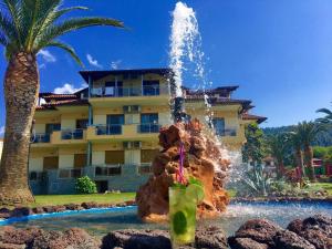 a fountain in the middle of a pool in front of a building at Vergos Hotel in Vourvourou