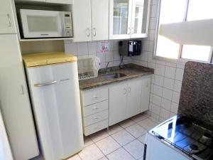 a kitchen with a white refrigerator and a microwave at Apartamentos Ecologic Park in Caldas Novas