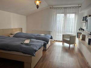 a bedroom with two beds and a chair and a television at Cheerful 4-bedroom & kids friendly home in Predeal