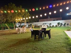 a group of tables and chairs in a field at night at Gulati farm in Bhundsi