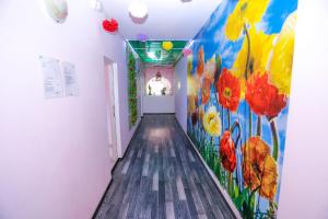 a hallway with a mural of flowers on the wall at Hostel Shatrata in Bogomilovo