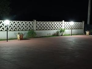 a white fence with two lights on it at night at La Villetta in Cutrofiano +7 photos