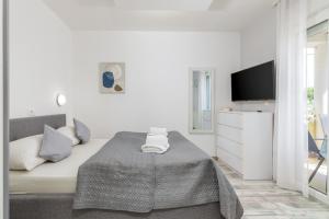 biała sypialnia z łóżkiem i telewizorem z płaskim ekranem w obiekcie Apartments Ana-Maria w Fažanie