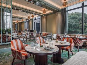 a restaurant with tables and chairs and large windows at The Silk Lakehouse, Shangri-La Hangzhou in Hangzhou