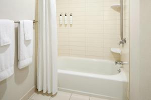 a bathroom with a white tub and a shower at Fairfield Inn & Suites by Marriott Montreal Airport in Dorval