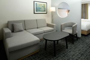 a living room with a couch and a table and a bed at Fairfield Inn & Suites by Marriott Montreal Airport in Dorval