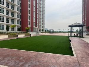 Un césped artificial en un patio entre dos edificios. en Stay at Anderson Condo1615 Ipoh Town, en Ipoh