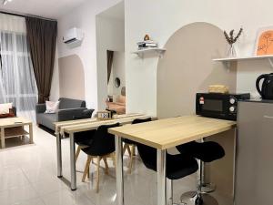 Una cocina y una sala de estar con mesa y sillas. en Stay at Anderson Condo1615 Ipoh Town, en Ipoh