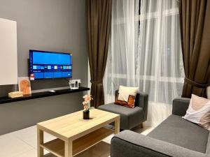 Una sala de estar con un televisor, un sofá y una mesa. en Stay at Anderson Condo1615 Ipoh Town, en Ipoh