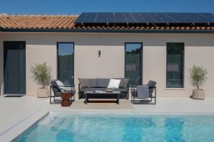 a patio with a couch and chairs next to a pool at Villa TonKa with jacuzzi sauna and private pool in Labin