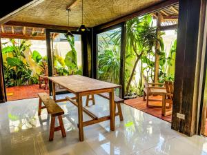 a wooden table and chair in a room with windows at Cosy Villa & Apartments - Siargao in General Luna +92 photos