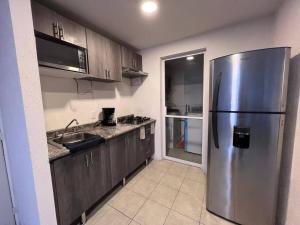 a kitchen with a stainless steel refrigerator and a sink at León in Guadalajara
