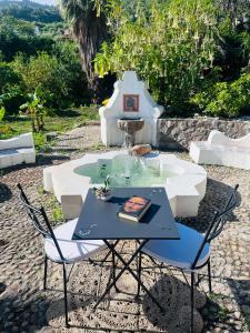 een tafel en stoelen voor een fontein bij Villa Tiche in Cefalù