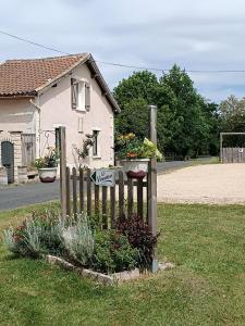 a wooden fence in front of a house with flowers at Les biches in Saint-Michel-de-Double