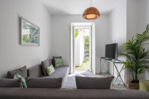 een woonkamer met een bank en een tv bij Charming and Cozy beach apartment in Estoril