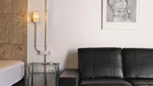 un canapé en cuir noir dans un salon avec une lampe dans l'établissement Nice Industrial Studio Teror 206, à Playa del Ingles 14 autres photos